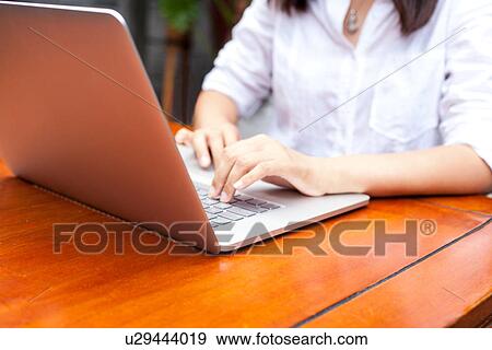 Young woman using laptop, outdoors, mid section View Large Photo Image Stock Photo - Young woman using laptop, outdoors, mid section. Fotosearch