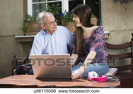 Young woman using laptop with grandfather View Large Photo Image Stock Photo - Young woman using laptop with grandfather. Fotosearch