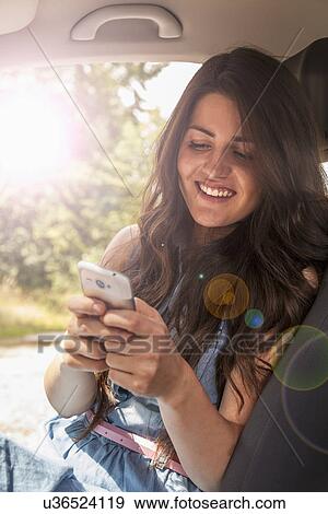 Young woman using smartphone View Large Photo Image Stock Photo - Young woman using smartphone. Fotosearch