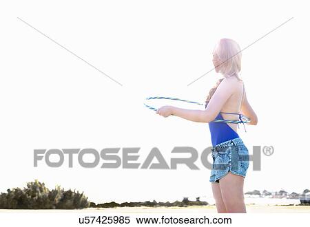 Young woman with hoola hoop on beach, Williamstown, Melbourne, Australia View Large Photo Image Stock Photography - Young woman with hoola hoop on beach, Williamstown, Melbourne, Australia. Fotosearch