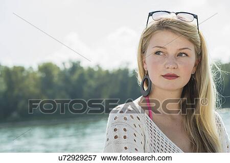 Young woman with long blonde hair looking away, portrait View Large Photo Image Stock Photo - Young woman with long blonde hair looking away, portrait. Fotosearch