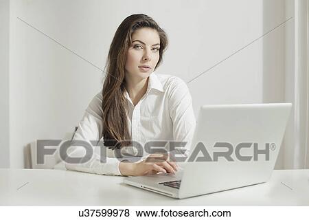 Stock Photo - Young woman working on laptop. Fotosearch