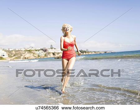 Blond woman running on beach View Large Photo Image Stock Photograph - Blond woman running on beach. Fotosearch