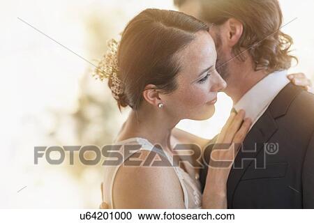 Stock Image - Bride and groom dancing cheek to cheek. Fotosearch