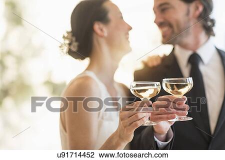 Bride and groom toasting with champagne View Large Photo Image Stock Image - Bride and groom toasting with champagne. Fotosearch