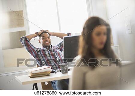 Stock Image - Businessman relaxing in office. Fotosearch