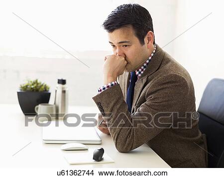 Businessman sitting in office and thinking View Large Photo Image Picture - Businessman sitting in office and thinking. Fotosearch