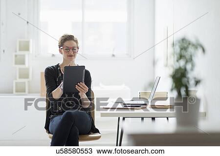 Businesswoman using digital tablet in office View Large Photo Image Stock Image - Businesswoman using digital tablet in office. Fotosearch