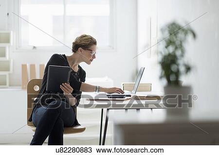 Businesswoman using laptop in office View Large Photo Image Stock Image - Businesswoman using laptop in office. Fotosearch
