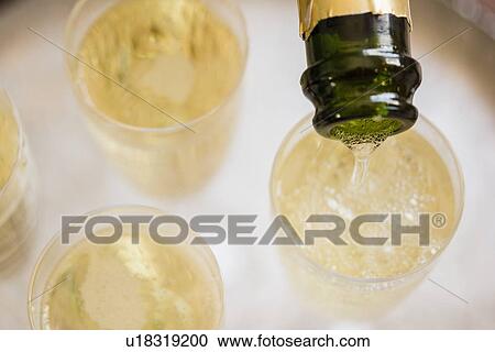 Stock Image - Champagne bottle and champagne flutes. Fotosearch
