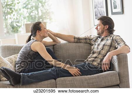Cheerful couple relaxing on sofa View Large Photo Image Stock Photography - Cheerful couple relaxing on sofa. Fotosearch