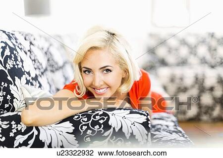 Close-up of woman lying down on sofa and smiling to camera View Large Photo Image Stock Image - Close-up of woman lying down on sofa and smiling to camera. Fotosearch