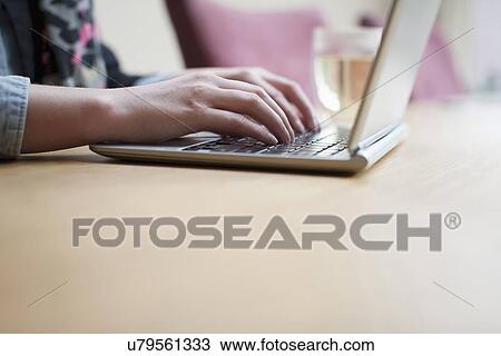 Stock Image - Close-up of woman using laptop. Fotosearch