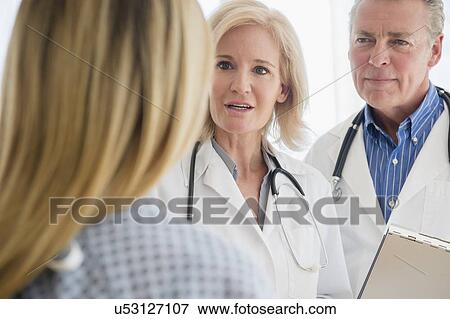 Close-up shot of two doctors talking to female patient View Large Photo Image Stock Photo - Close-up shot of two doctors talking to female patient. Fotosearch