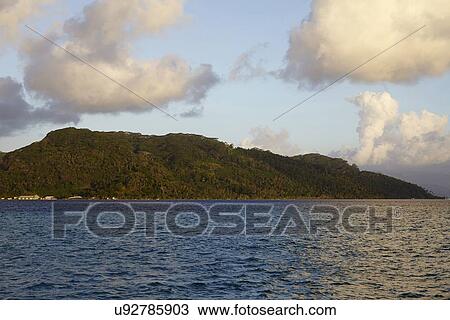 Stock Image - Cloudy sky above islands in sea. Fotosearch