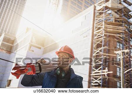 Construction worker carrying tripod on shoulder View Large Photo Image Stock Image - Construction worker carrying tripod on shoulder. Fotosearch
