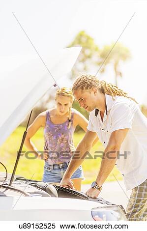 Stock Photography - Couple checking car engine. Fotosearch
