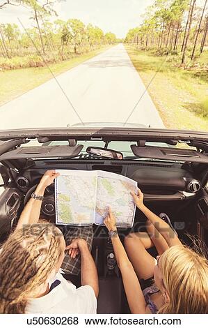 Couple checking map while driving View Large Photo Image Stock Photo - Couple checking map while driving. Fotosearch
