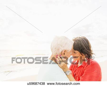 Couple face to face on beach at sunrise View Large Photo Image Stock Photo - Couple face to face on beach at sunrise. Fotosearch