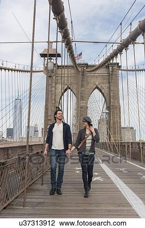 Couple holding hands and walking on Brooklyn Bridge View Large Photo Image Stock Image - Couple holding hands and walking on Brooklyn Bridge . Fotosearch