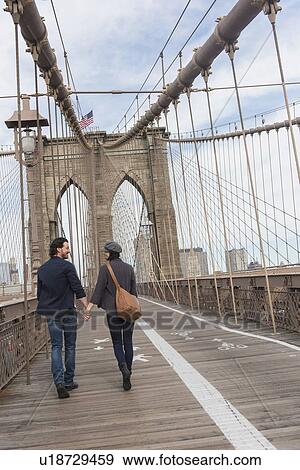 Couple holding hands and walking on Brooklyn Bridge View Large Photo Image Stock Photo - Couple holding hands and walking on Brooklyn Bridge . Fotosearch