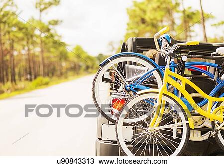 Stock Image - Couple in car with bike rack. Fotosearch