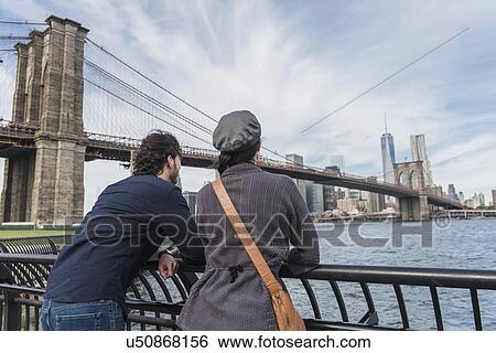 Couple leaning against railing and looking at Freedom Tower View Large Photo Image Stock Photograph - Couple leaning against railing and looking at Freedom Tower . Fotosearch
