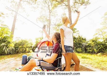 Couple looking for range on cell phone View Large Photo Image Stock Photography - Couple looking for range on cell phone. Fotosearch