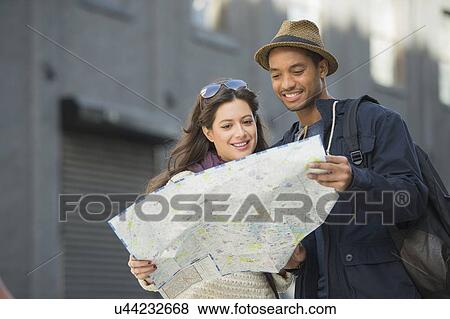 Stock Photo - Couple reading map on street. Fotosearch