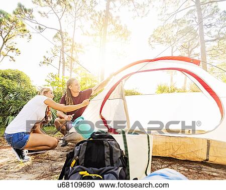 Couple setting up tent in forest View Large Photo Image Stock Image - Couple setting up tent in forest. Fotosearch