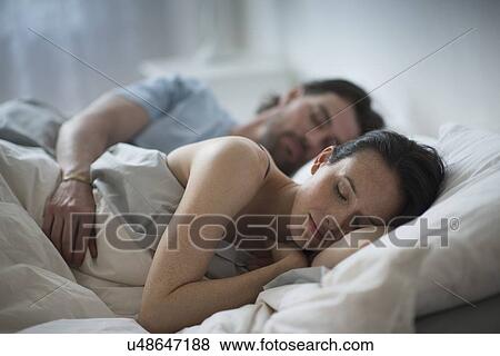Couple sleeping together in bed at night View Large Photo Image Stock Photo - Couple sleeping together in bed at night. Fotosearch