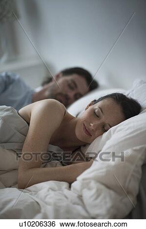 Couple sleeping together in bed at night View Large Photo Image Stock Photograph - Couple sleeping together in bed at night. Fotosearch