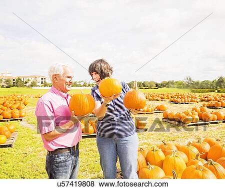 Couple talking and holding pumpkins View Large Photo Image Stock Photo - Couple talking and holding pumpkins . Fotosearch