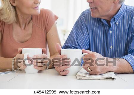 Cropped shot of husband and wife drinking coffee and talking View Large Photo Image Stock Photography - Cropped shot of husband and wife drinking coffee and talking. Fotosearch