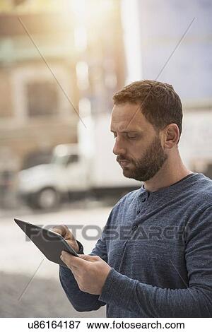 Delivery man using digital tablet View Large Photo Image Stock Photo - Delivery man using digital tablet. Fotosearch