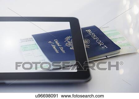 Stock Image - Digital tablet, airplane tickets and passport. Fotosearch