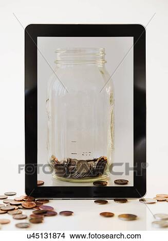 Picture - Digital tablet and savings jar. Fotosearch