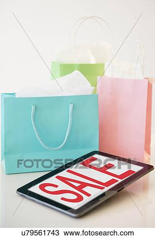 Digital tablet and shopping bags View Large Photo Image Stock Image - Digital tablet and shopping bags. Fotosearch