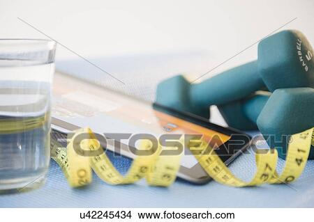 Picture - Dumbbells, tape measure and digital tablet. Fotosearch