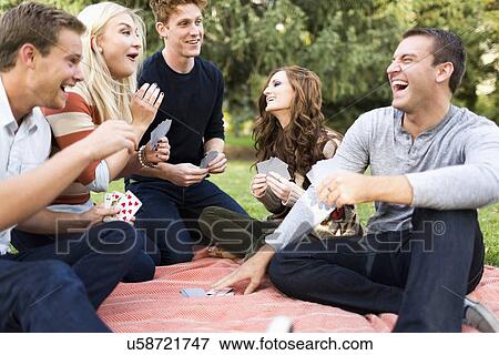 Friends playing cards in park View Large Photo Image Stock Photo - Friends playing cards in park. Fotosearch
