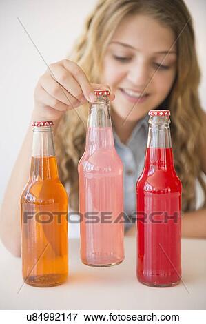 Girl (12-13) and three soda bottles View Large Photo Image Stock Photo - Girl (12-13) and three soda bottles. Fotosearch