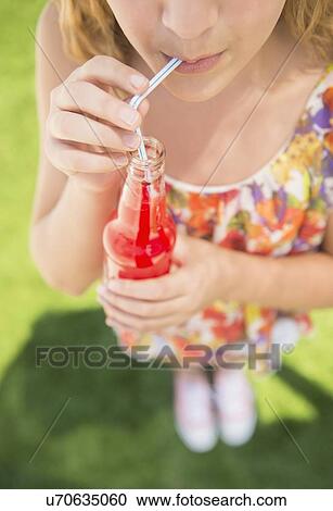 Girl (12-13) drinking soda from bottle using straw View Large Photo Image Stock Image - Girl (12-13) drinking soda from bottle using straw. Fotosearch