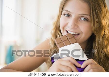 Girl (12-13) eating chocolate View Large Photo Image Stock Photo - Girl (12-13) eating chocolate. Fotosearch