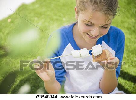 Girl (12-13) eating marshmallows View Large Photo Image Picture - Girl (12-13) eating marshmallows. Fotosearch