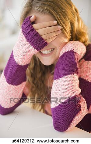 Girl (12-13) grinning and covering eyes View Large Photo Image Stock Image - Girl (12-13) grinning and covering eyes. Fotosearch