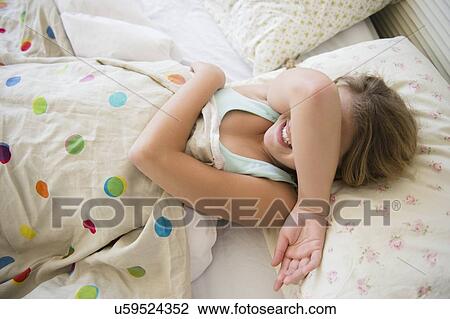 Girl (12-13) lying in bed covering her face View Large Photo Image Stock Image - Girl (12-13) lying in bed covering her face. Fotosearch