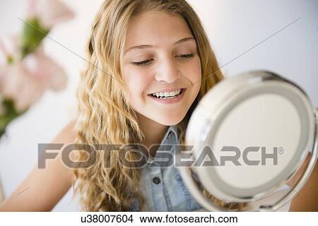 Girl (12-13) smiling to mirror View Large Photo Image Picture - Girl (12-13) smiling to mirror. Fotosearch
