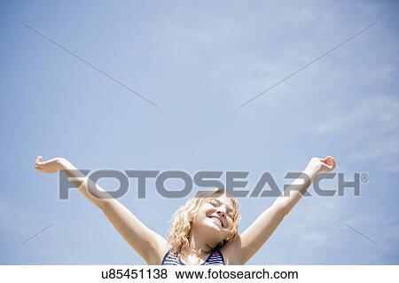 Girl (12-13) with arms raised, smiling View Large Photo Image Stock Photo - Girl (12-13) with arms raised, smiling. Fotosearch