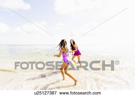 Girl (6-7) and her mom enjoying themselves on beach View Large Photo Image Stock Photo - Girl (6-7) and her mom enjoying themselves on beach. Fotosearch