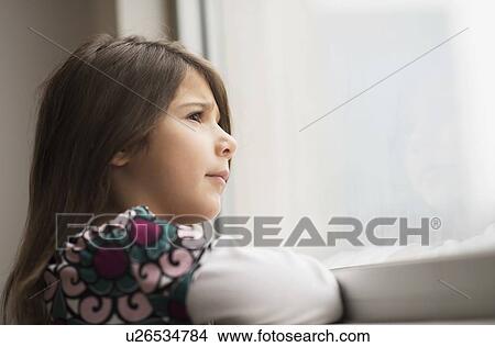 Girl (6-7) looking out of window View Large Photo Image Picture - Girl (6-7) looking out of window. Fotosearch